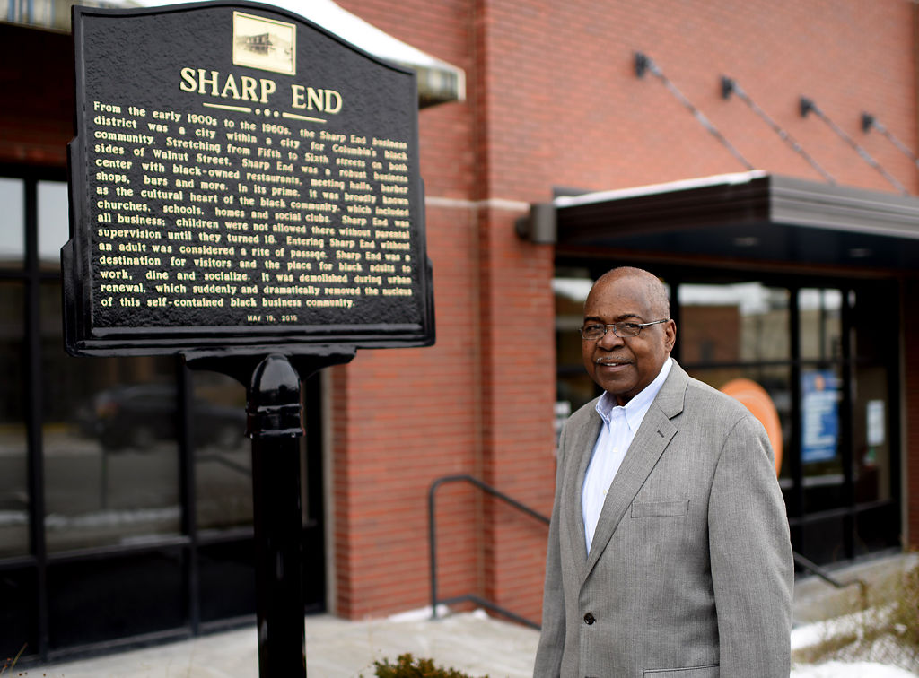 James Whitt stands in front of a historical marker denoting the location of the historically black business district